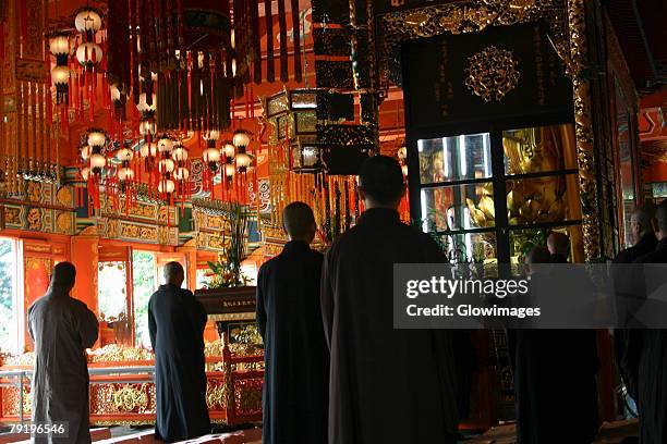 rear view of a group of people praying in a monastery, po lin monastery, ngong ping, lantau, hong kong, china - mosteiro de po lin imagens e fotografias de stock