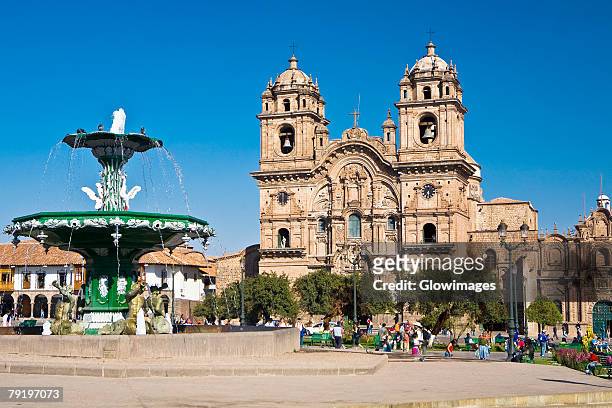 fountain in front of a church, la compania, plaza-de-armas, cuzco, peru - plaza de armas stock pictures, royalty-free photos & images