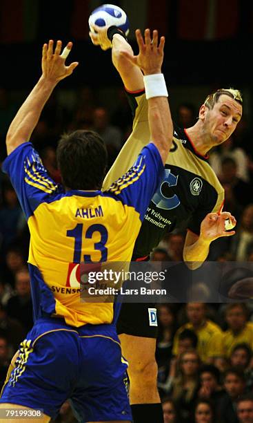 Markus Ahlm of Sweden in action with Pascal Hens of Germany during the Men's Handball European Championship main round Group II match between Germany...
