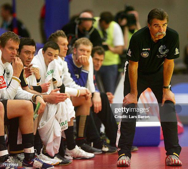 Coach Heiner Brand of Germany looks on next to his players during the Men's Handball European Championship main round Group II match between Germany...