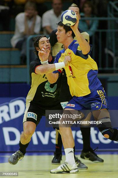 Sweden's right back Kim Andersson tries to shoots as he faces Germany's left wing Torsten Jansen during their 8th Men's European Handball...