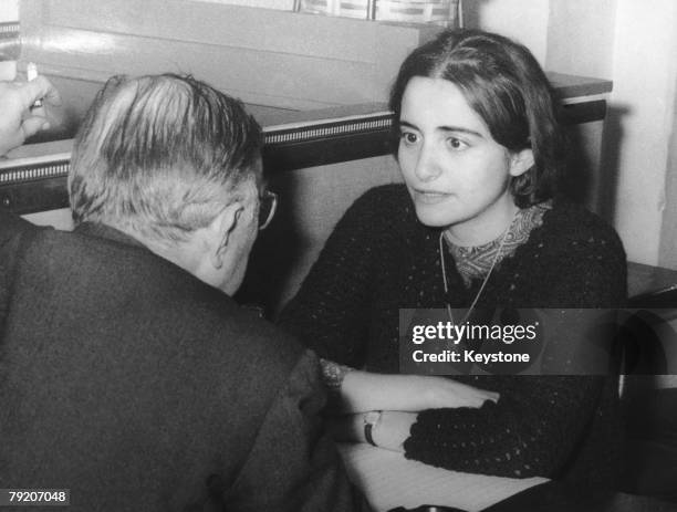 French writer and philosopher Jean-Paul Sartre at a cafe in Montparnasse with his 28-year-old secretary Arlette Elkaim, whom he is in the process of...