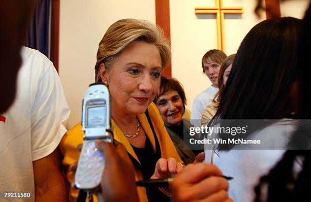 Democratic presidential candidate Sen. Hillary Clinton signs her autograph on the back of a T-shirt as she greets supporters following a campaign...