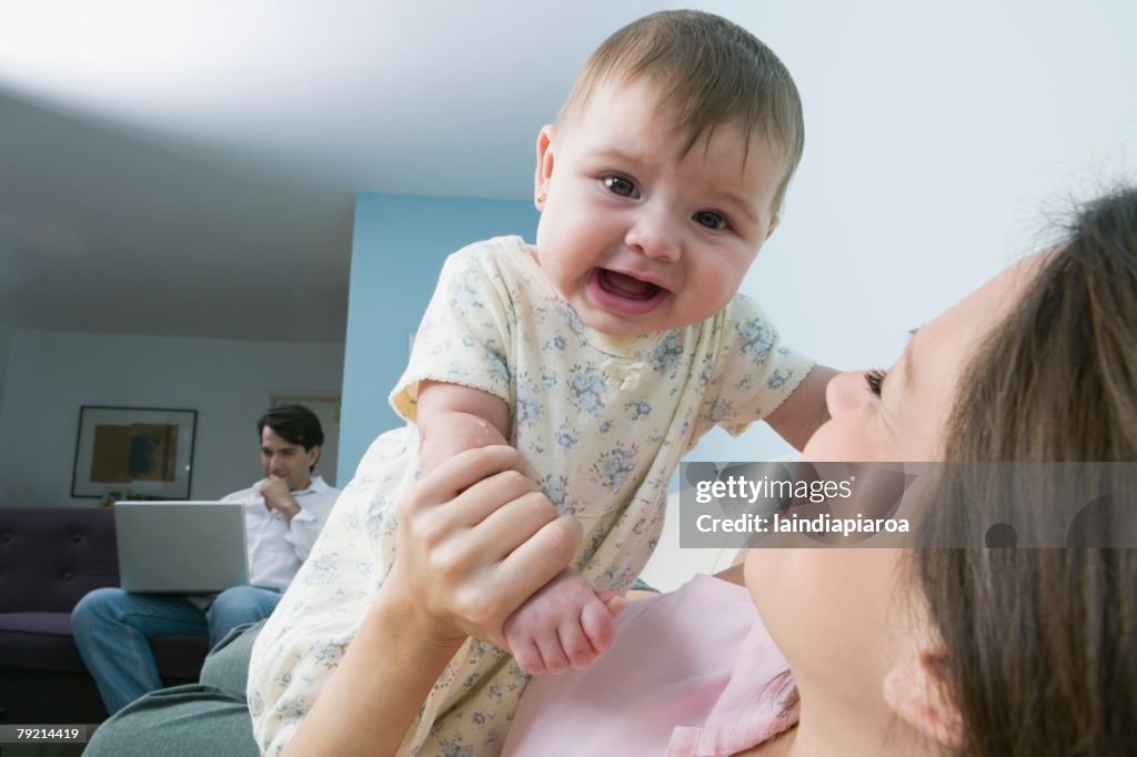 Hispanic mother playing with baby