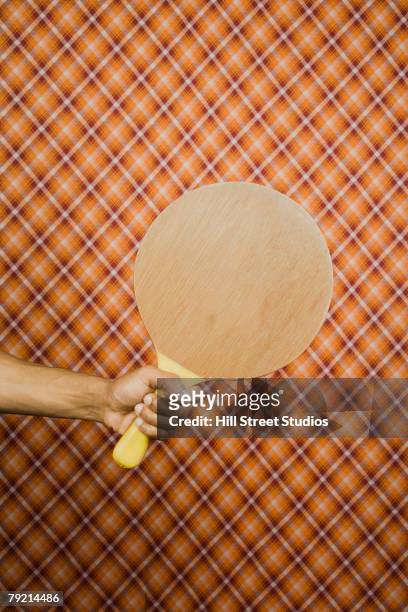 young man holding a large ping-pong paddle - pala de tenis de mesa fotografías e imágenes de stock