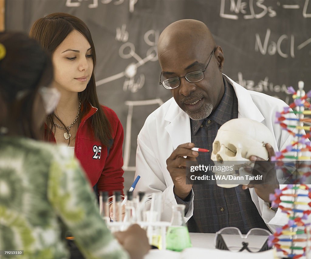 African male science teacher showing students a human skull, Toronto, Canada