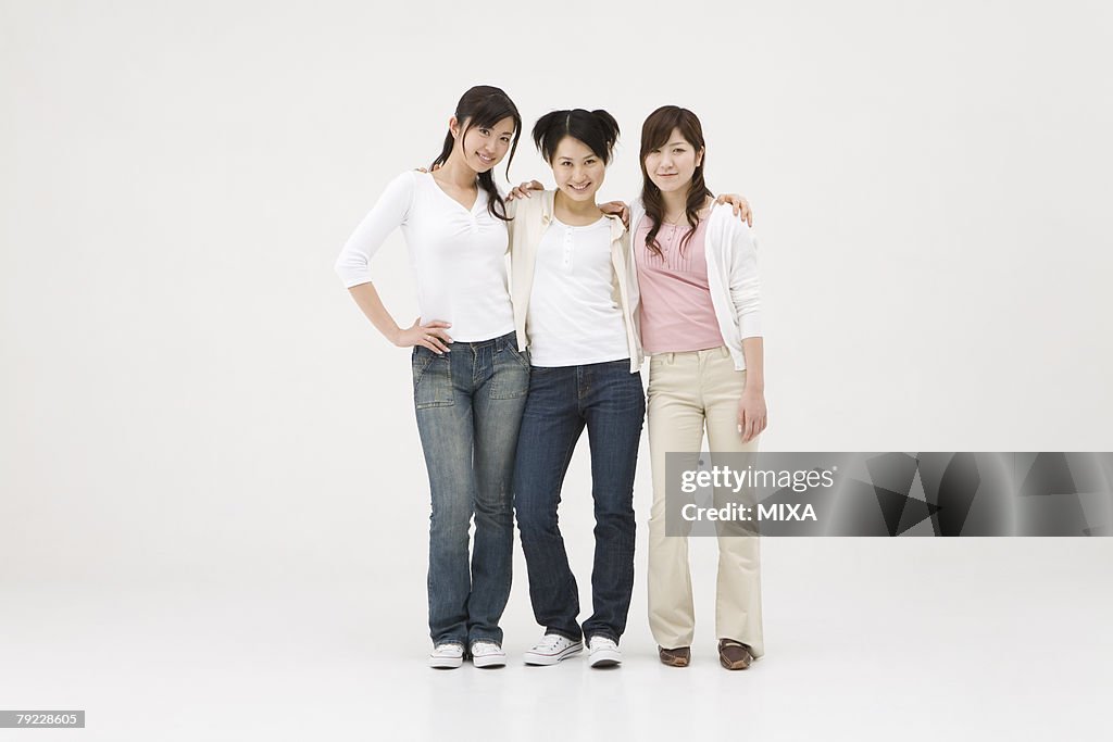 Three young women standing with arms around