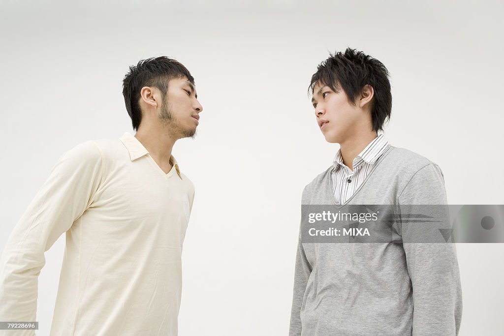 Two young men glaring at each other