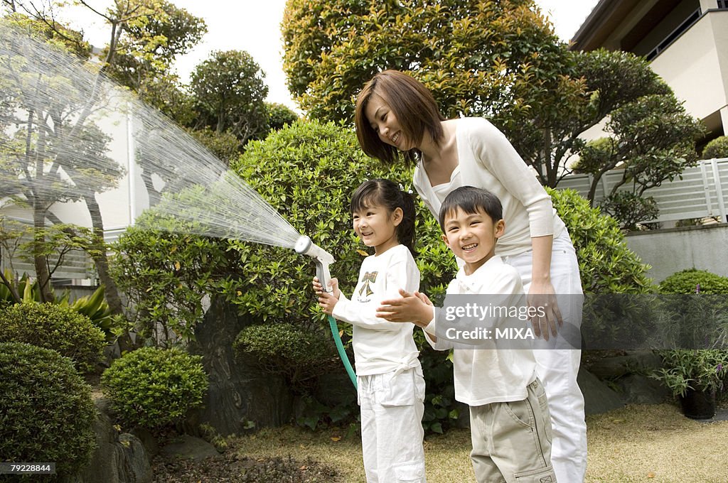 Mother and children watering trees