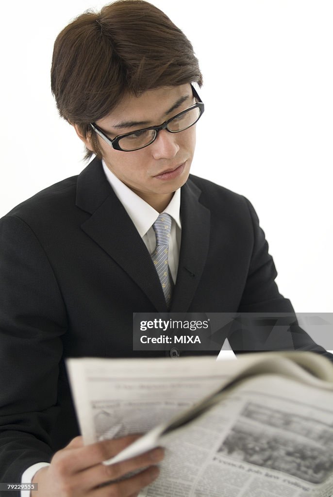 Young businessman reading newspaper