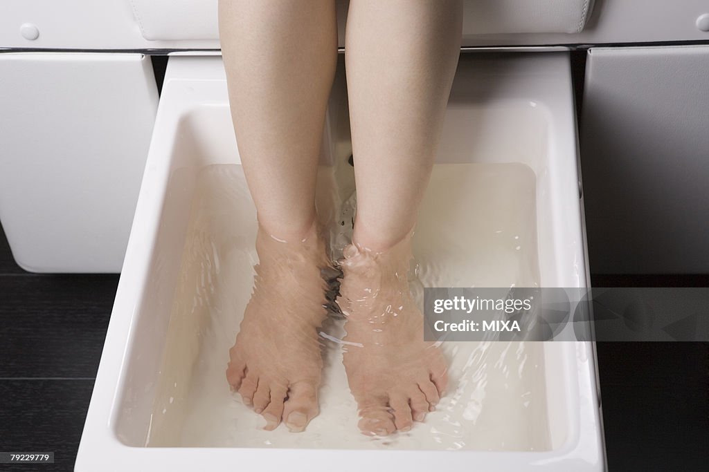 Young woman having foot bath