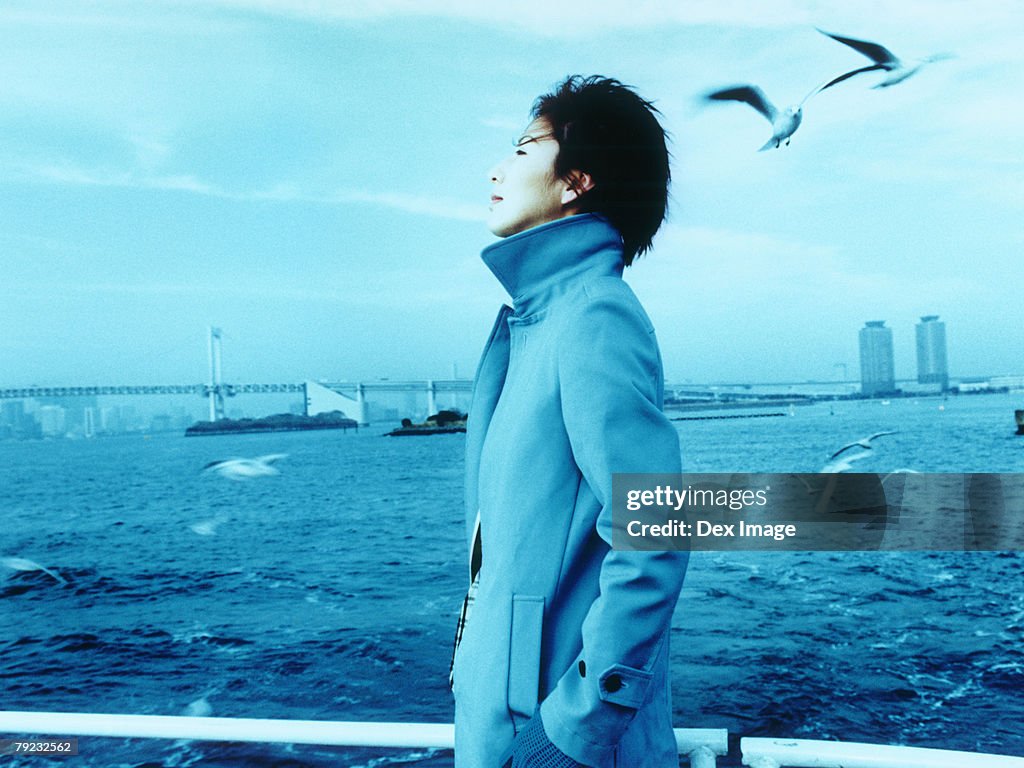 Young woman with Tokyo city in background, a flock of seagulls