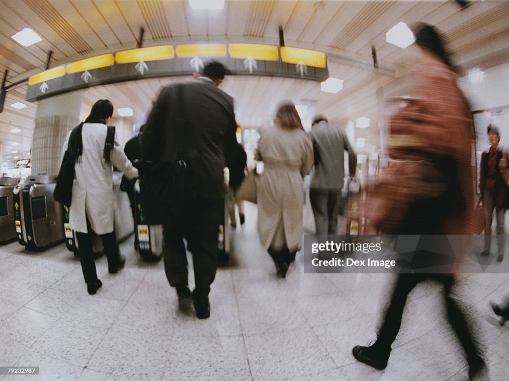 Commuters going though turnstile (blurred motion)