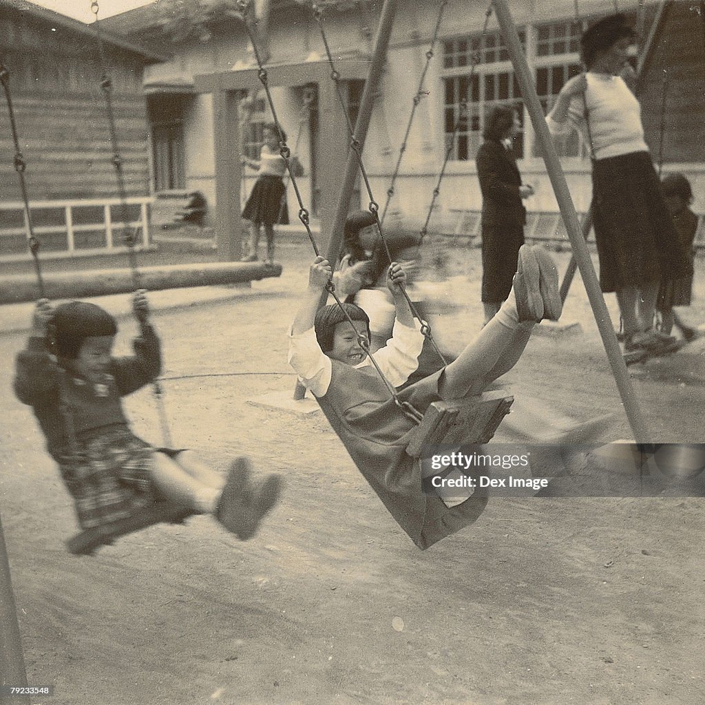 Girls playing on swings in a playground