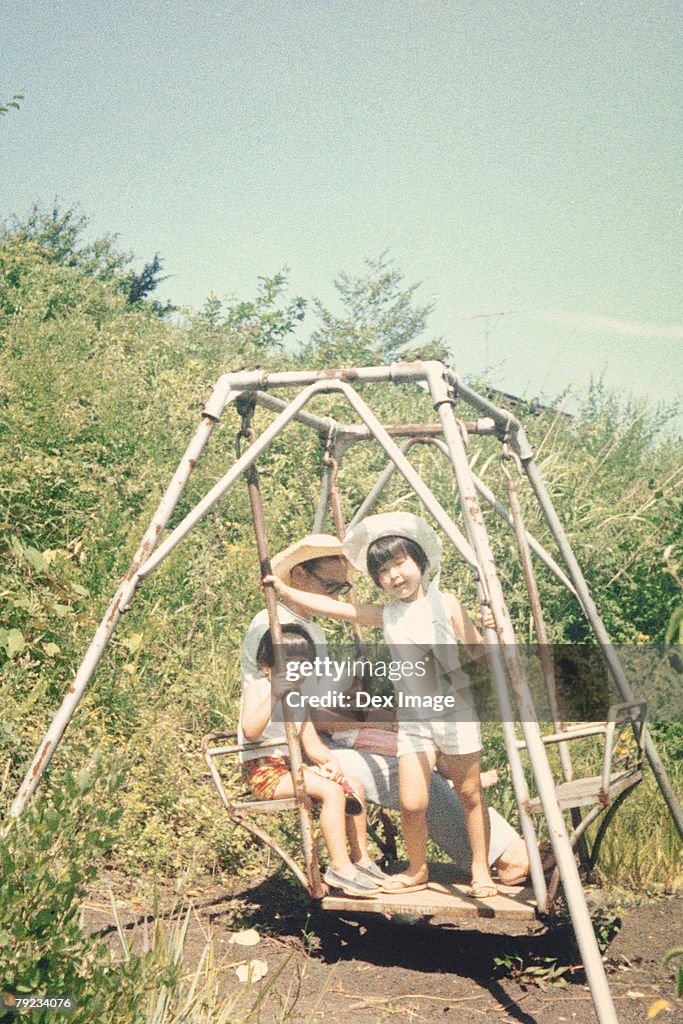 Father and children on a swing