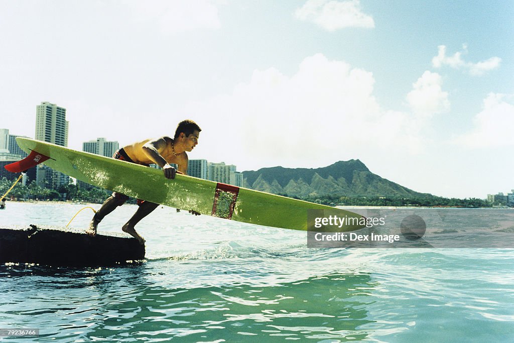 Young man jumping off with surfboard