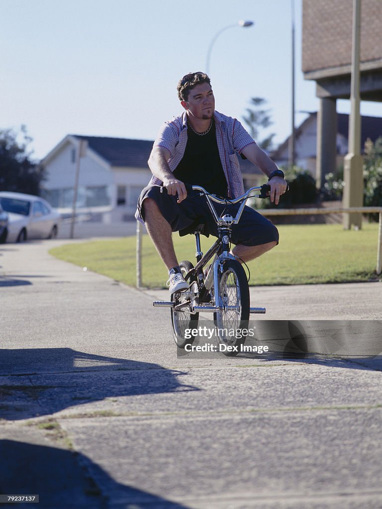 Young man cycling on pavement