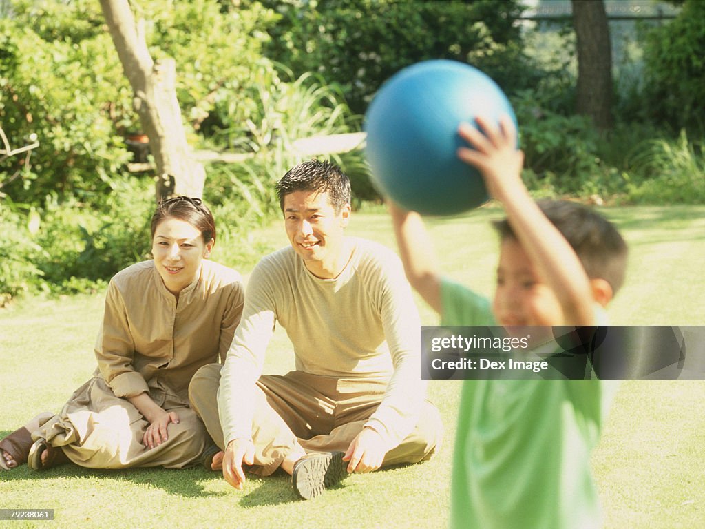 Father and mother watching son playing ball games
