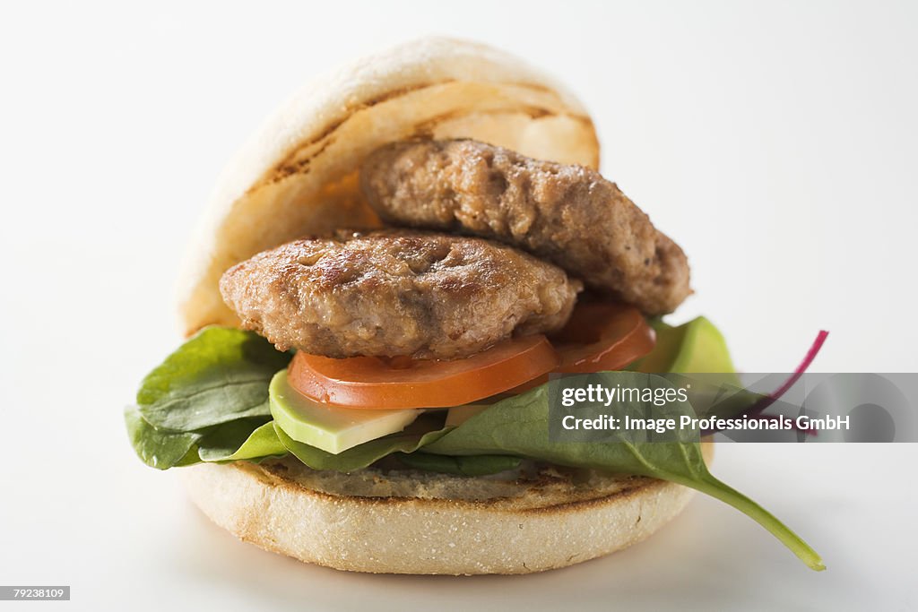Meat patties with spinach and avocado in hamburger roll