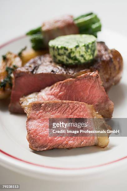 beef steak with herb butter and bacon-wrapped beans - entrecôte stockfoto's en -beelden