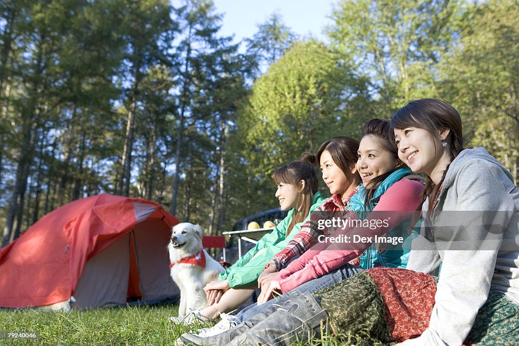 Four girls and a dog sitting on grass