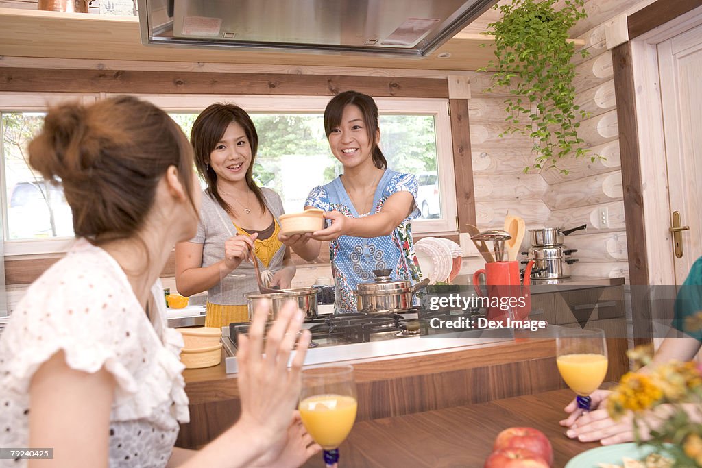 A group of young women cooking in the kitchen