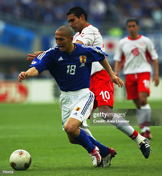 Shinji Ono of Japan takes the ball past Kaies Ghodhbane of Tunisia during the FIFA World Cup Finals 2002 Group H match played at the Osaka-Nagai...