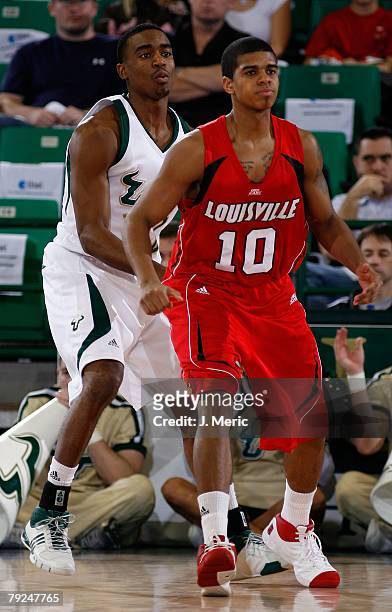 Edgar Sosa of the Louisville Cardinals looks for the ball as Solomon Bozeman of the South Florida Bulls guards him during the game on January 23,...
