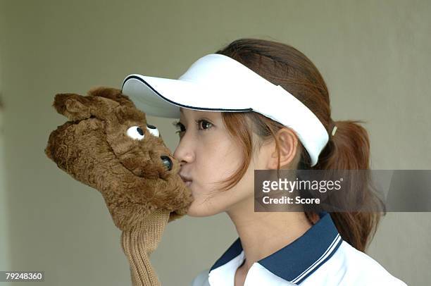 close up of the woman kissing the head cover of a golf club - golf driver stock pictures, royalty-free photos & images