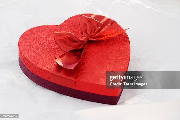 heart shaped box of chocolates - romantic couple on white background stock-fotos und bilder