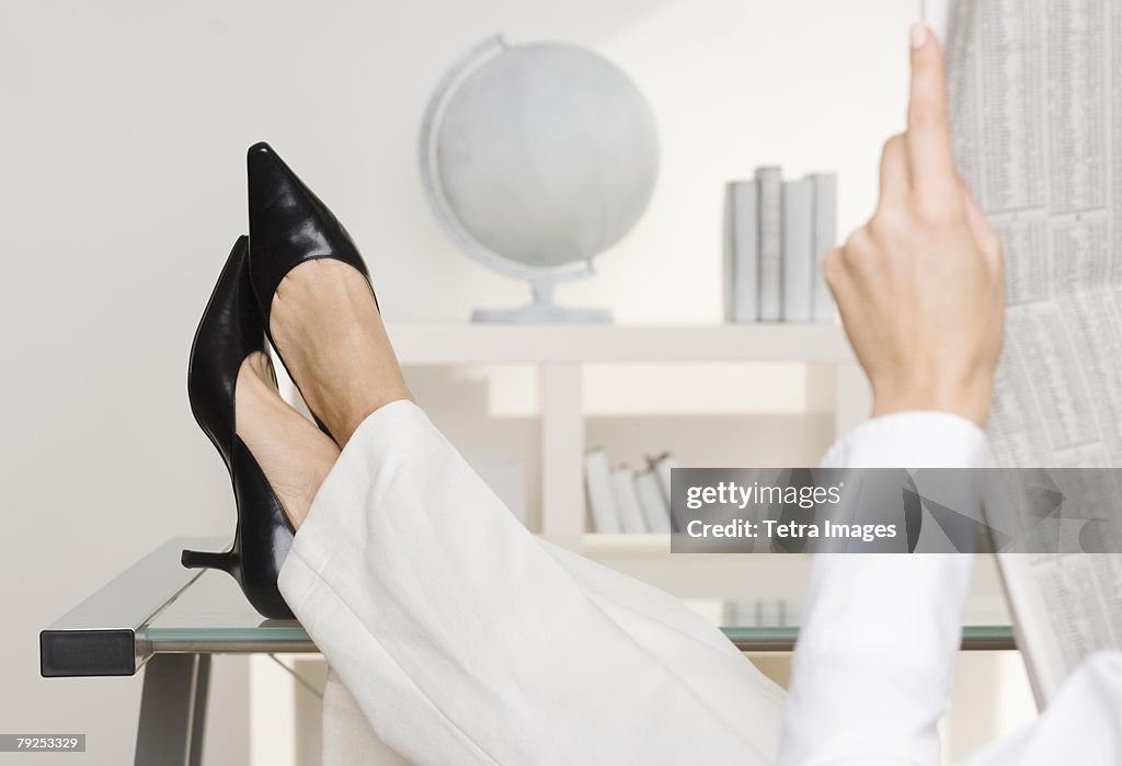 Woman reading newspaper business page