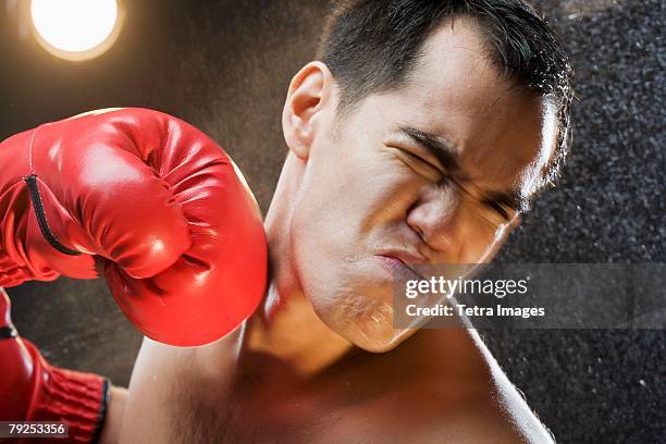 boxer taking a punch to the head - punching imagens e fotografias de stock