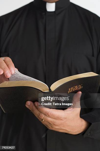 close up of bible in priest?s hands - cuello clerical fotografías e imágenes de stock