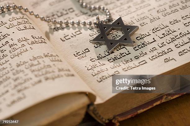 star of david necklace on book with hebrew text - judeu imagens e fotografias de stock