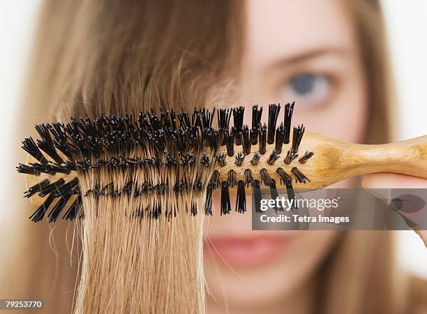 close up of hairbrush in woman?s hair - brushing hair stock-fotos und bilder