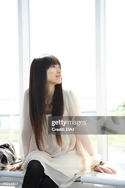 woman sitting on the bench, front view, three quarter length - three quarter front view stockfoto's en -beelden