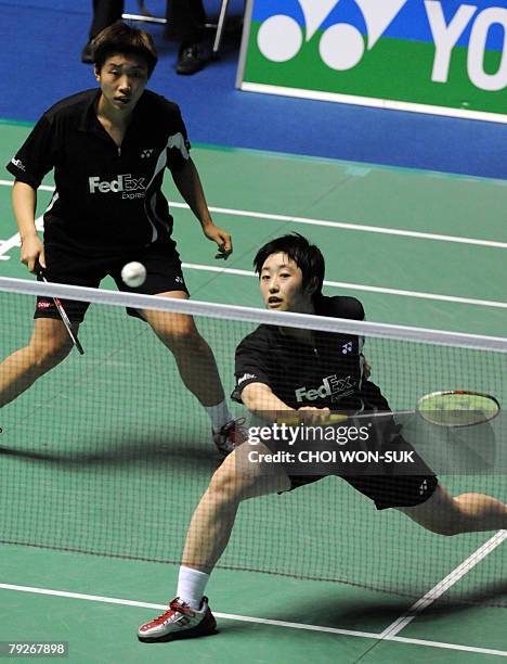 China's Jing Du hits a return as her partner Yang Yu looks on during the women's doubles semi-final match against China's Yawen Zhang and Yili Wei in...