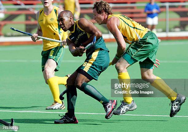Julian Hykes of South Africa shoots at goal with David Guest of Australia defending during the Five Nations Mens Hockey tournament match between...