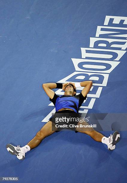 Novak Djokovic of Serbia falls to the ground after winning championship point after his men's final match against Jo-Wilfried Tsonga of France on day...
