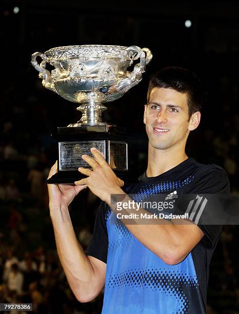 Novak Djokovic of Serbia holds aloft the Norman Brookes Challenge Cup after winning the men's final match against Jo-Wilfried Tsonga of France on day...