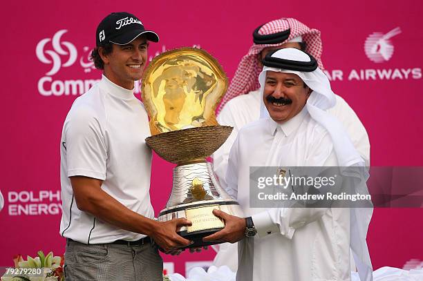 Adam Scott of Australia receives the trophy from Hassan Nasser Al Naimi, President of the Qatar Golf Association, after winning the Commercialbank...