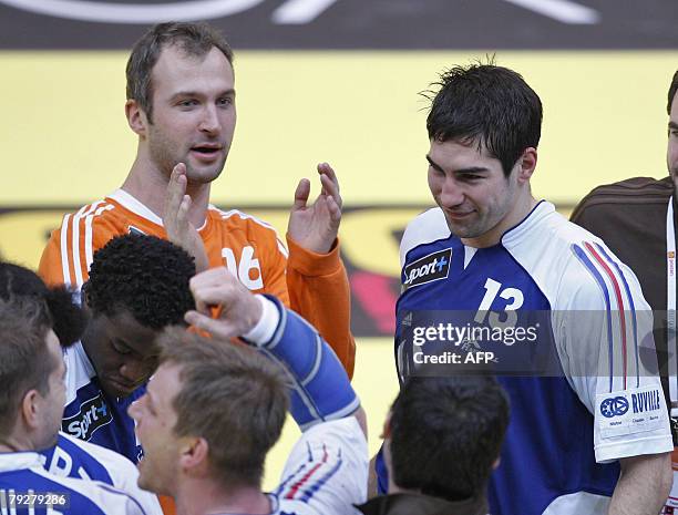 France's left back Nikola Karabatic stands next teammate France's goalkeeper Thierry Omeyer as they celebrate their victory on Germany at the end of...