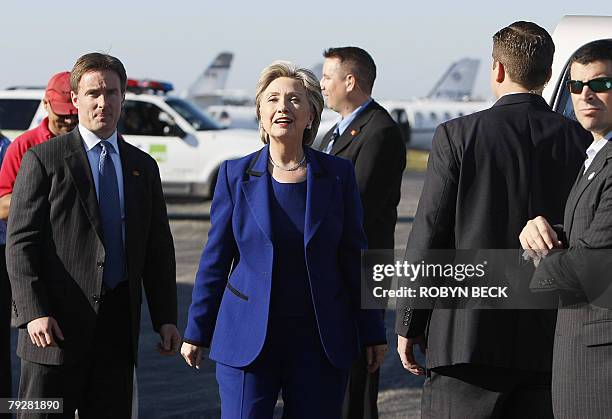 Democratic presidential hopeful New York Senator Hillary Clinton, surrounded by Secret Service agents, greets the press as she arrives on the airport...