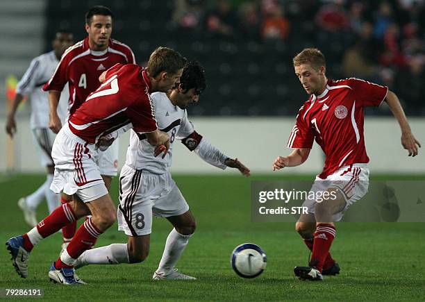 Qatar's Saad al-Shammari vies for the ball with Denmark players Henrik Hansen and Chris Sorensen while Mikkel Beckmann stands alert during their...