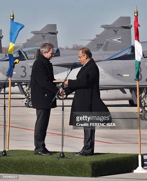 Sweden's Minister of Defense Sten Tolgfors , and his Hungarian counterpart Imre Szekeres, shake hands during the hand over ceremony of the Swedish...