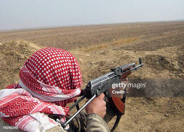 An anti-Qaeda 'Awakening' group fighter, known as Concerned Local Citizens , scans an area at the entrance of a village on the southern outskirts of...