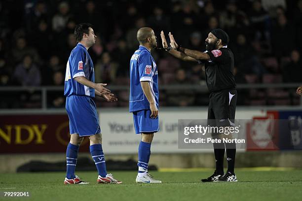 Referee Jarnail Singh gestures to Adam Chambers and Adam Boyd of Leyton Orient during the Coca Cola League One Match between Northampton Town and...