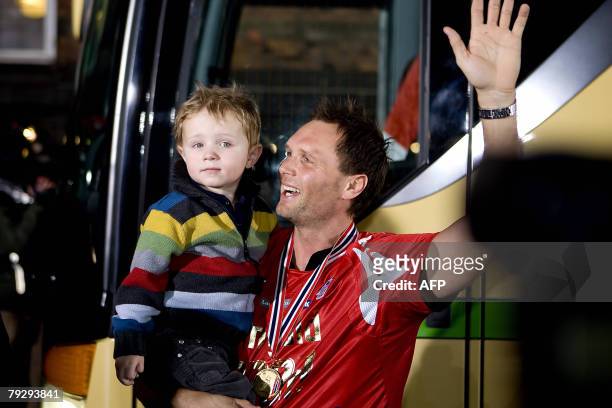 With his two-year-old son Frederik on his arm the Danish player Lars Christiansen, who plays for the German club Flensburg-Handewitt, waves 28...
