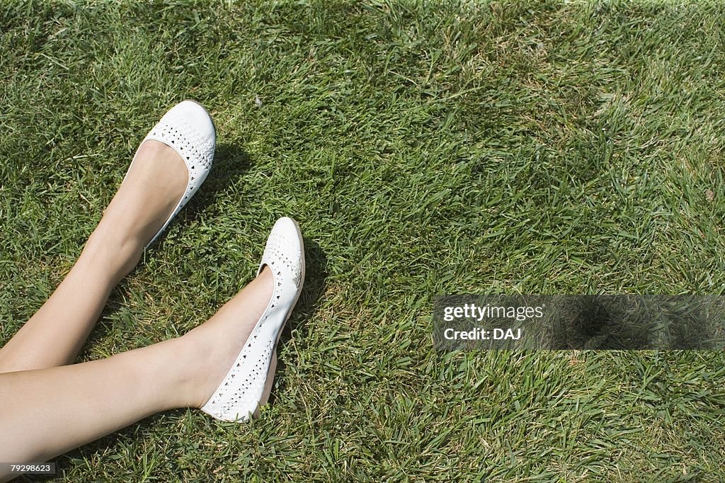 Womans Legs resting on grass, High Angle View, Copy Space