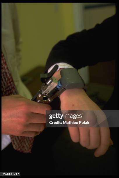 Bracelets électroniques Geografix - Installation du bracelet de surveillance à distance, riveté au poignet du prisonnier, qui ne peut et ne doit...